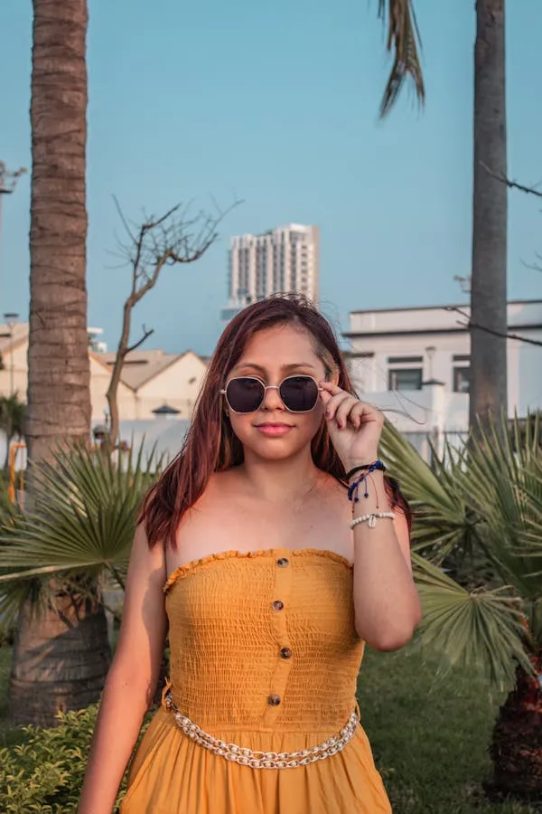 Woman in a Yellow Top Enjoying a Sunny Day with a Smile
