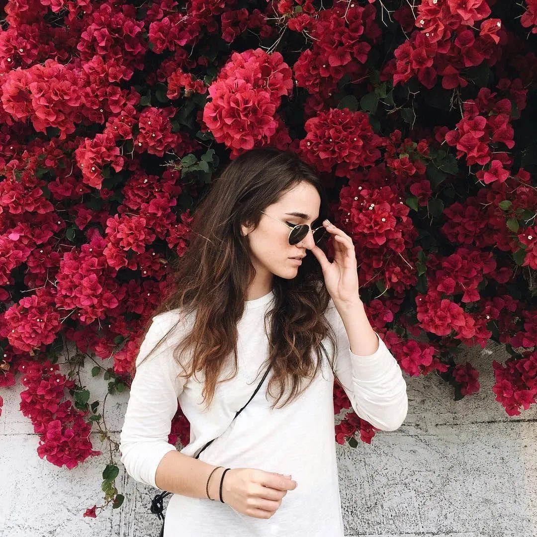 Woman in a Yellow Top Sitting Indoors with Glasses Wallpaper