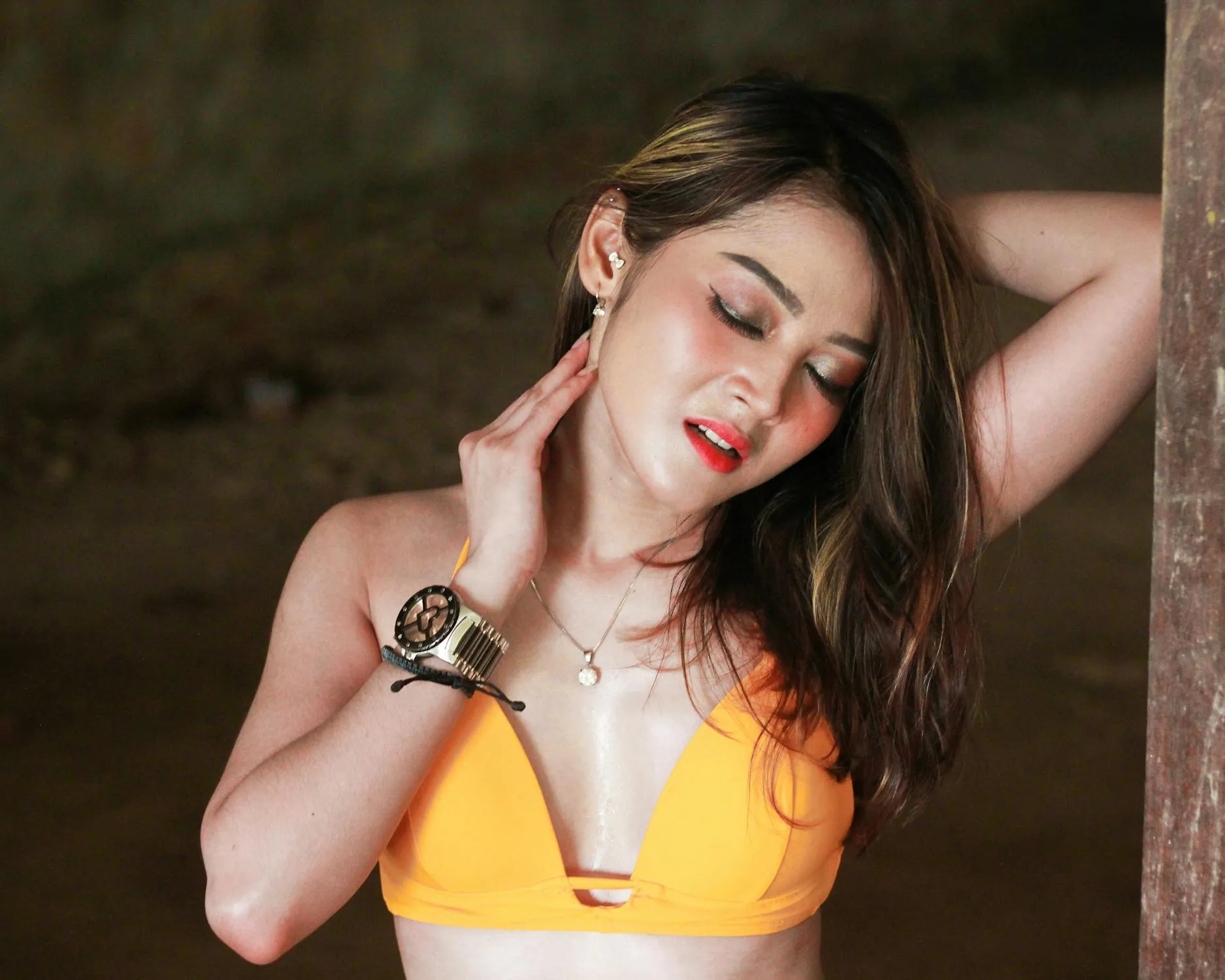 Woman in a Yellow Top Touching Neck in Outdoor Natural Light