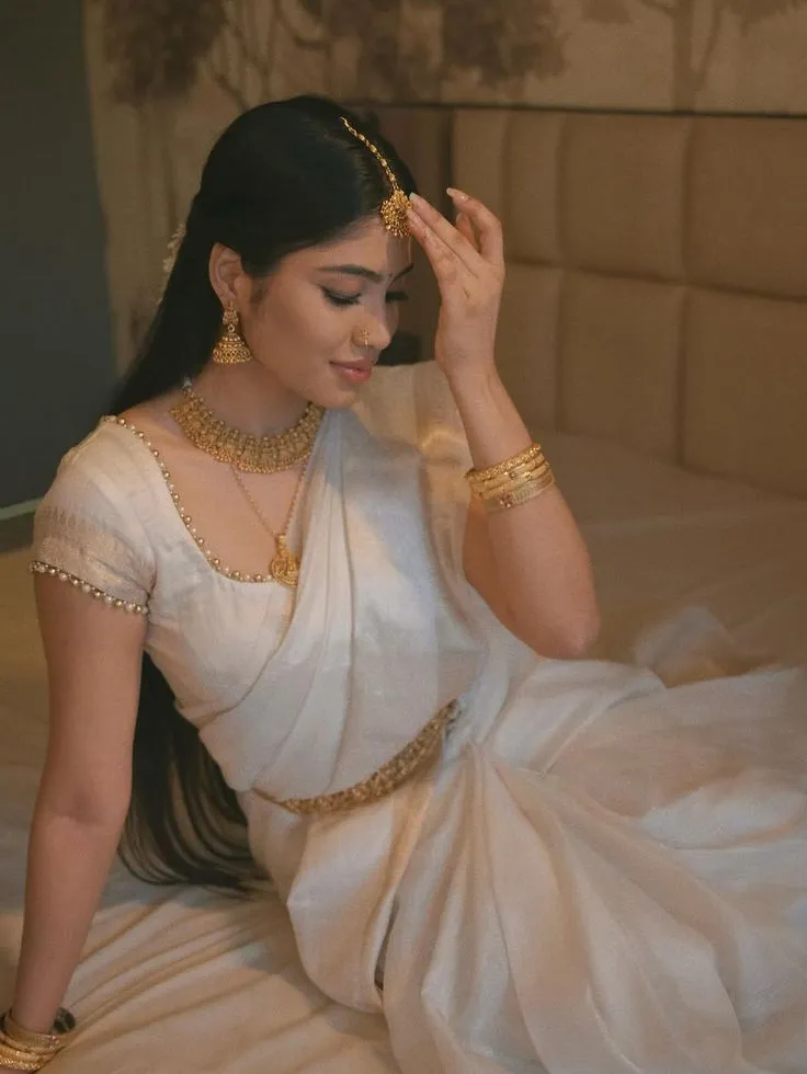 Yashi Tank in a traditional Kerala saree sitting on floor