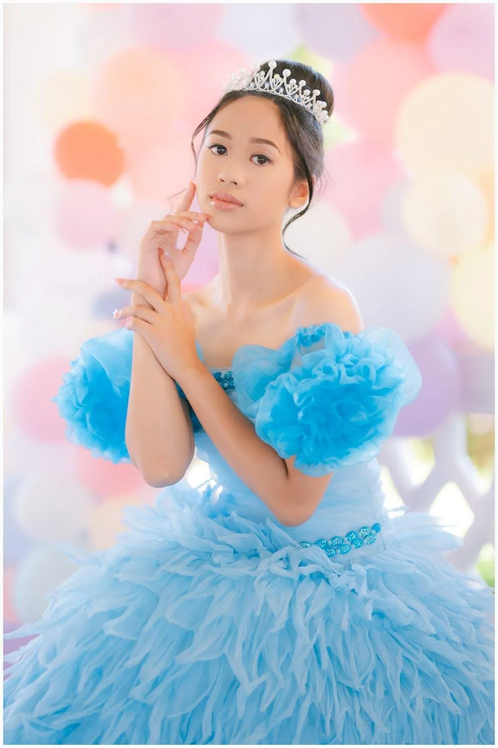 Young Girl in a Blue Ruffled Gown in a Playful Studio Scene