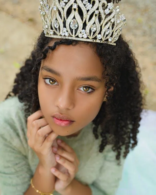 Young Girl in a Crown Posing Outdoors with Gentle Expression