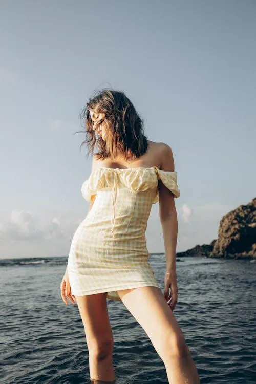 Young Model in White Dress Walking on Rocky Beach Wallpaper