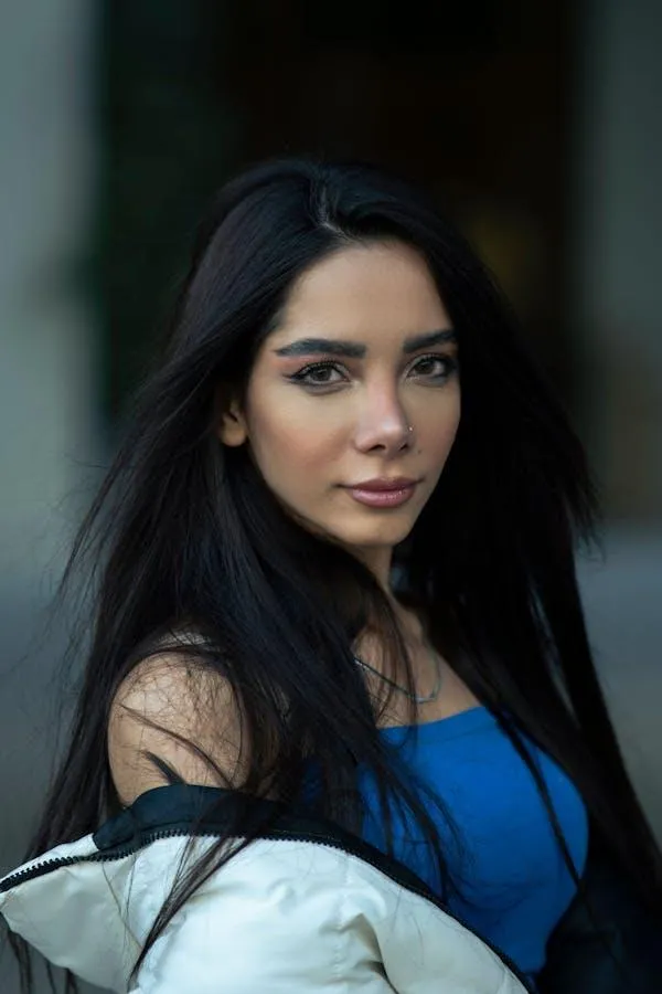 Young Woman in a Blue Top Posing Confidently Outdoors Image