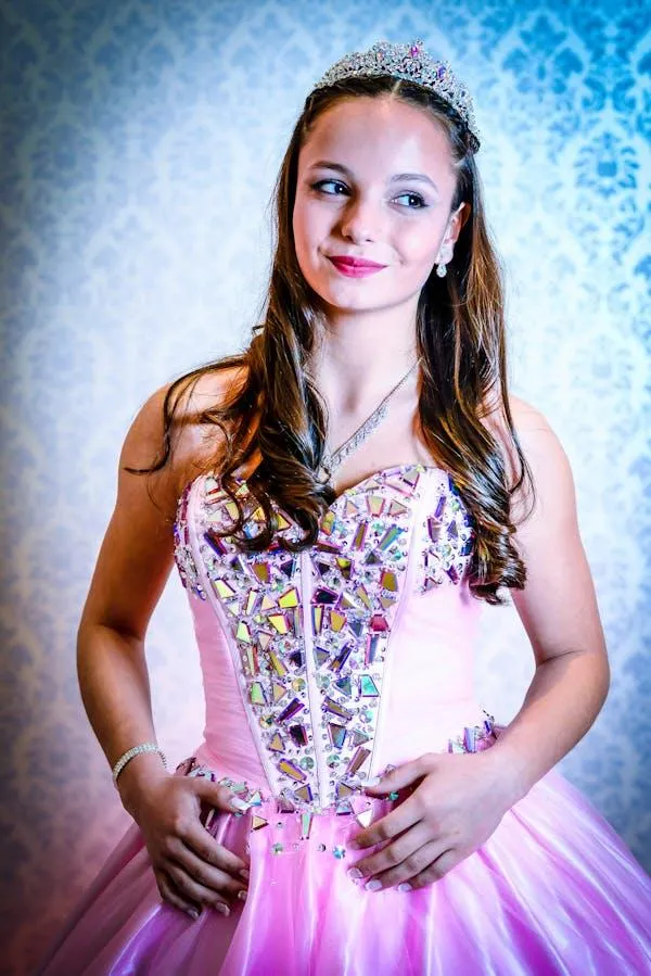 Young Woman in Elegant Pink Dress Smiling and Posing Indoors