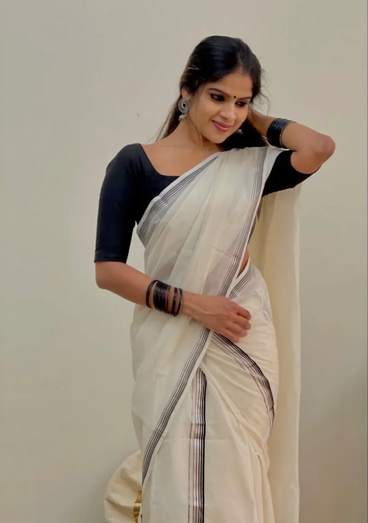 Young woman in a set Mundu dress hand on her hair wallpaper