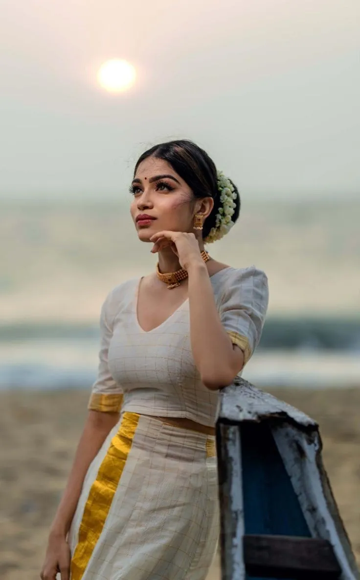 Young woman in a traditional Kerala dress with a sunrise image