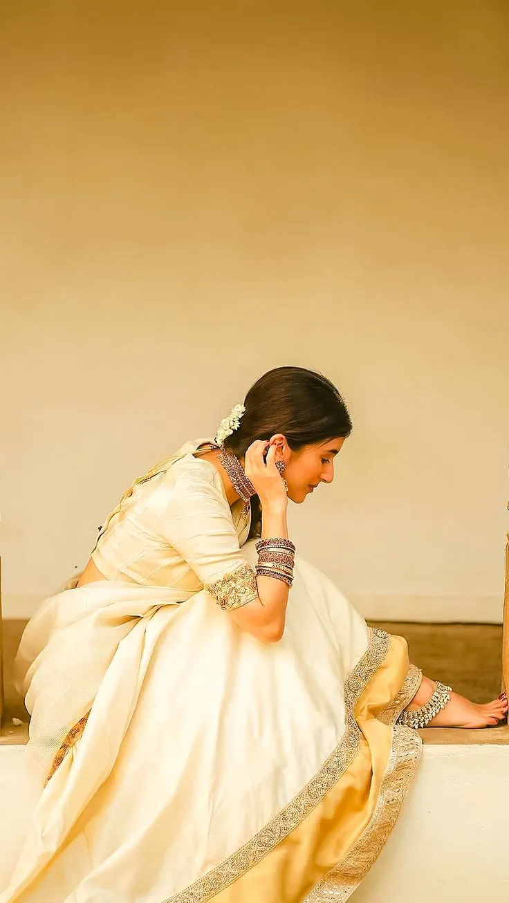 Young woman in a white dress with her hand on her ear image