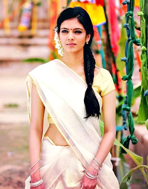 Young woman in an Onam saree with a colorful background