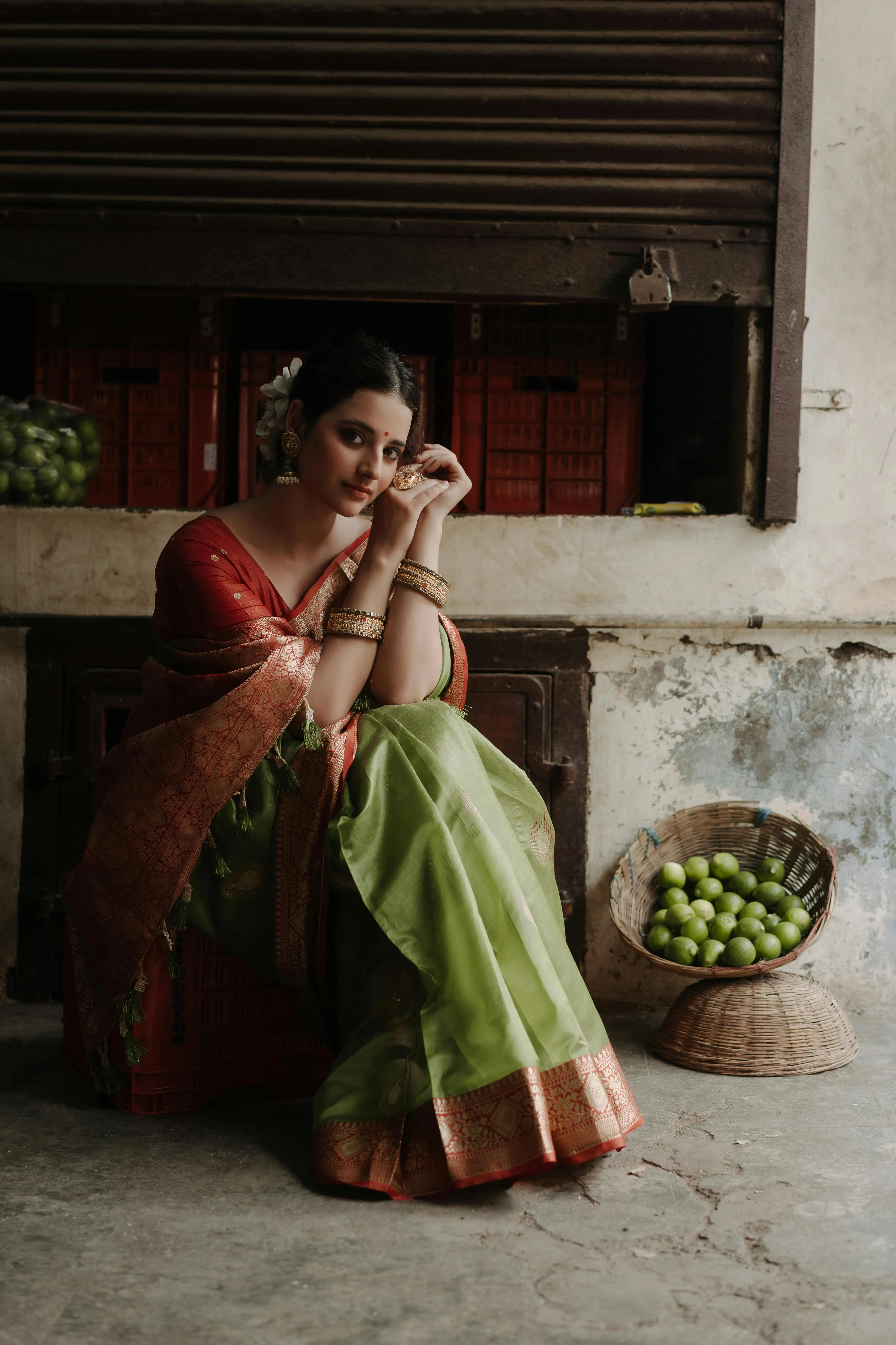 Young Woman in Green Saree Posing Near Traditional Wall