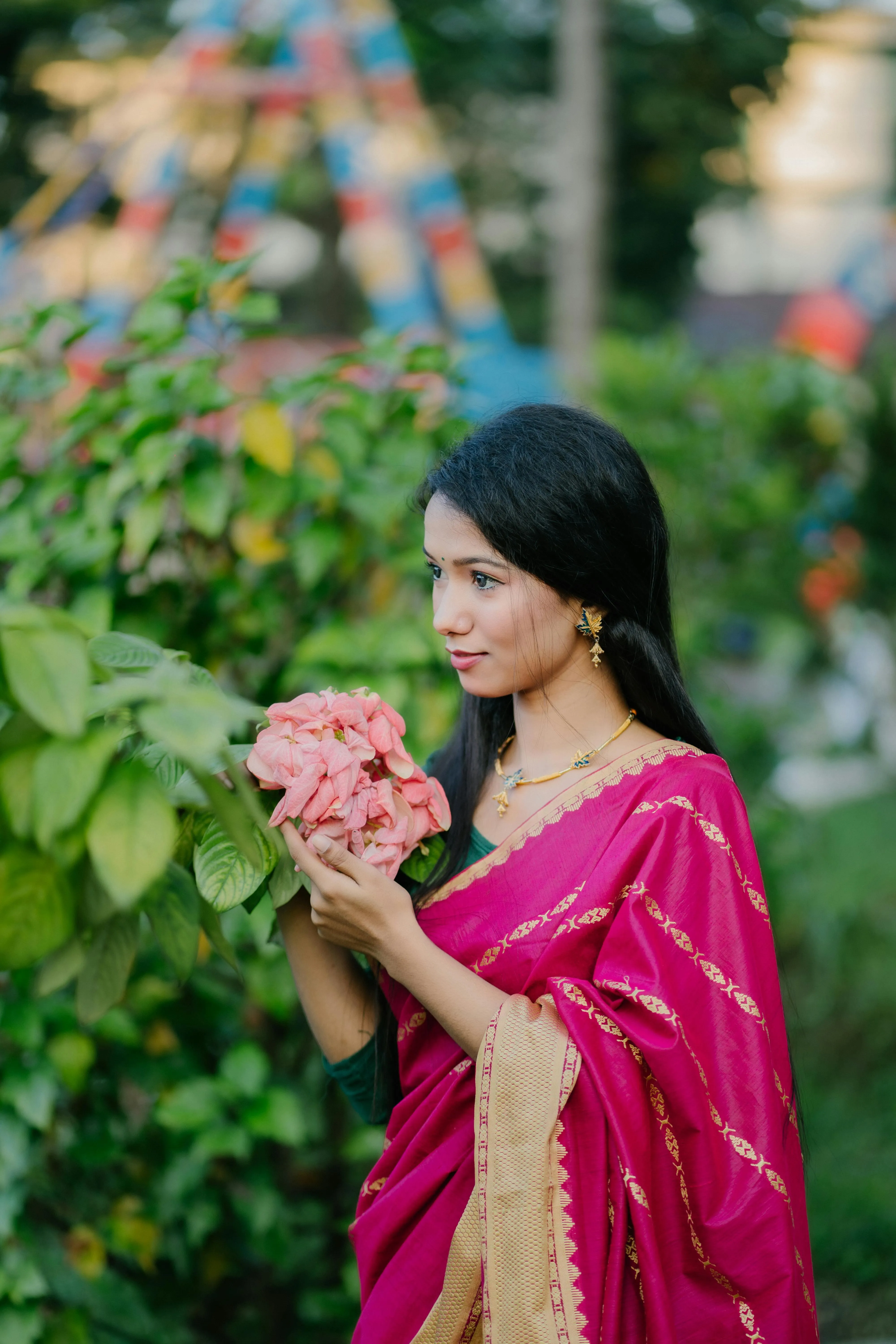 Young Woman in Pink Saree Holding Flower with Smile Picture
