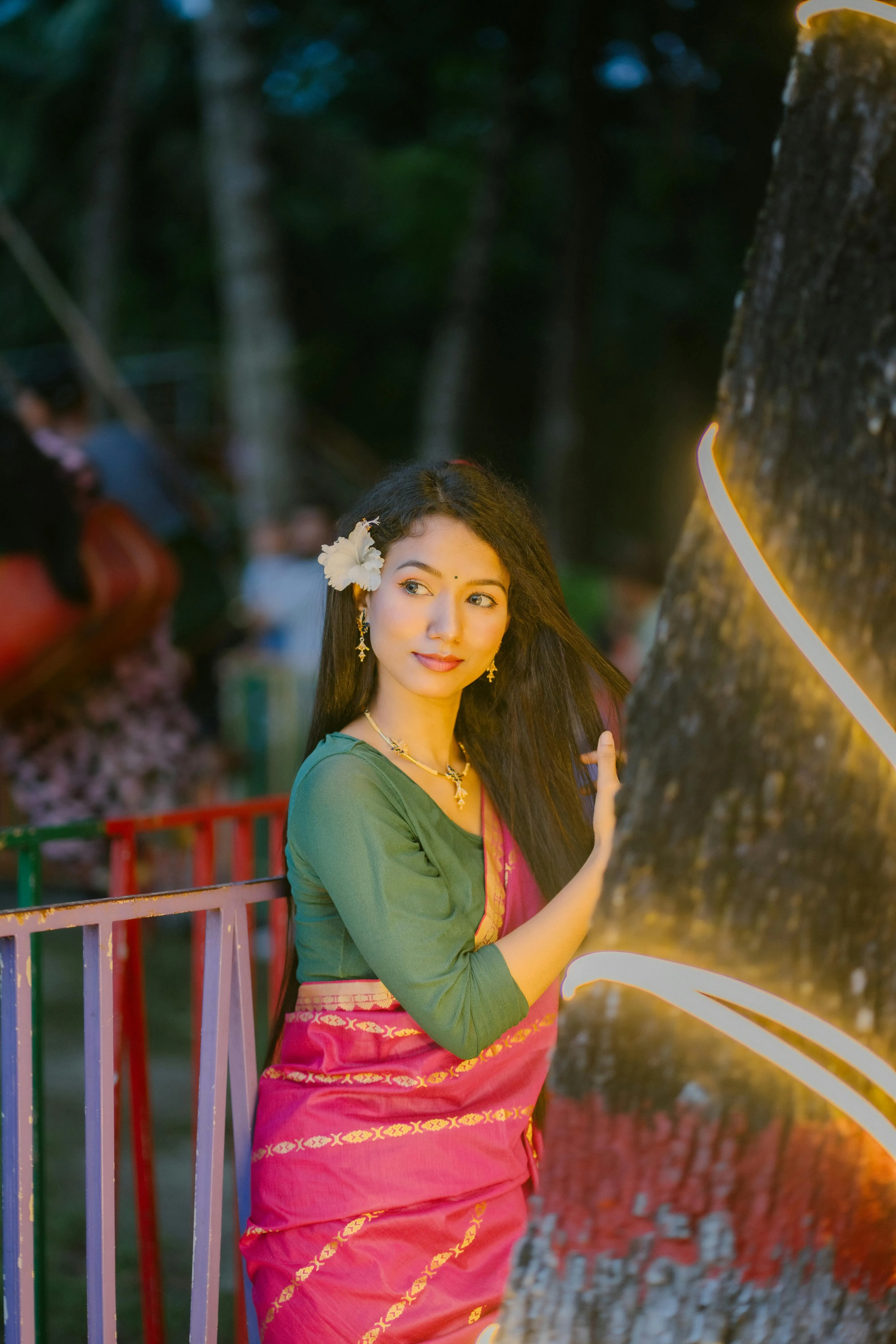 Young Woman in Pink Saree with Festive Lights in Night Image