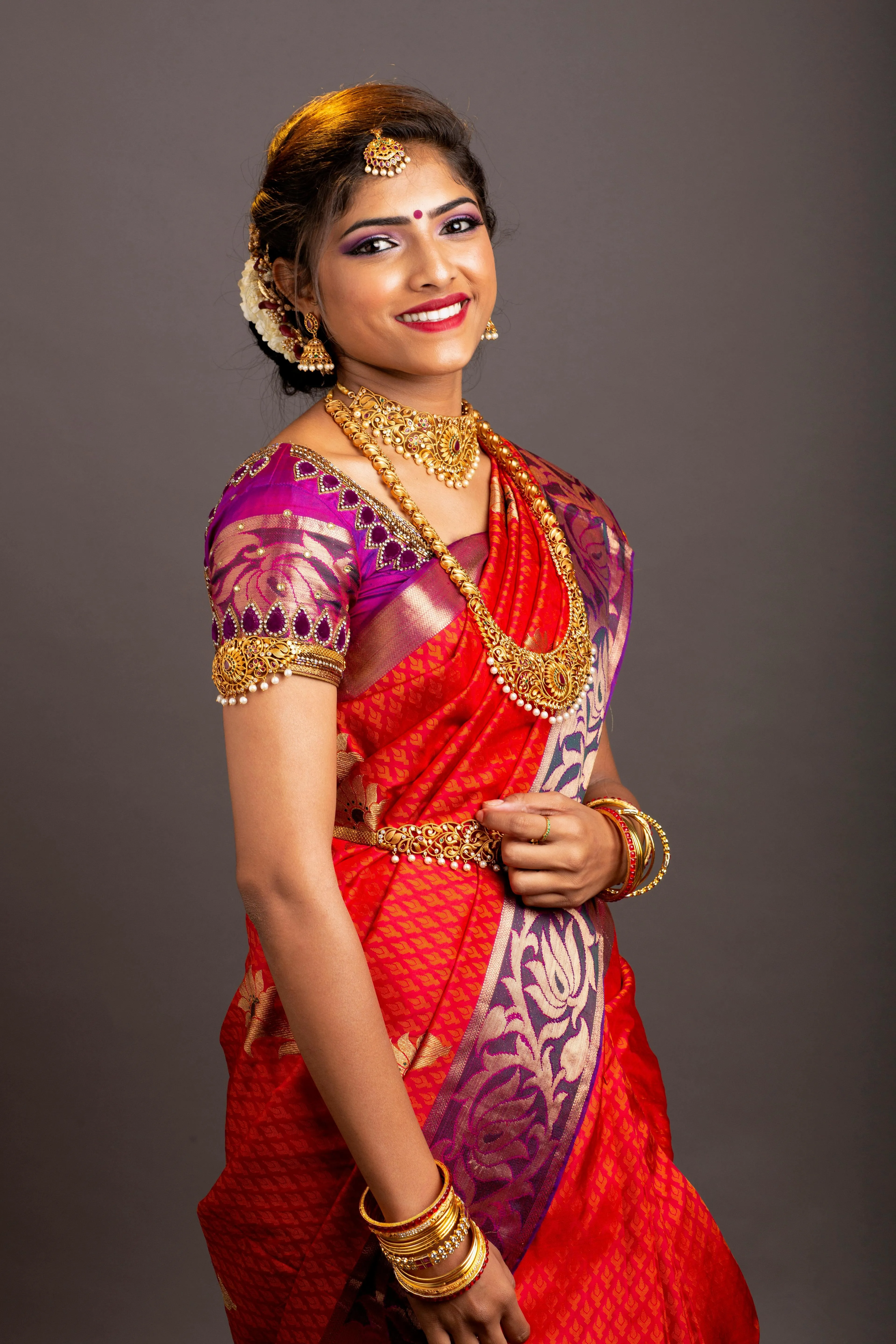 Young Woman in Red Silk Saree Posing with Royal Elegance