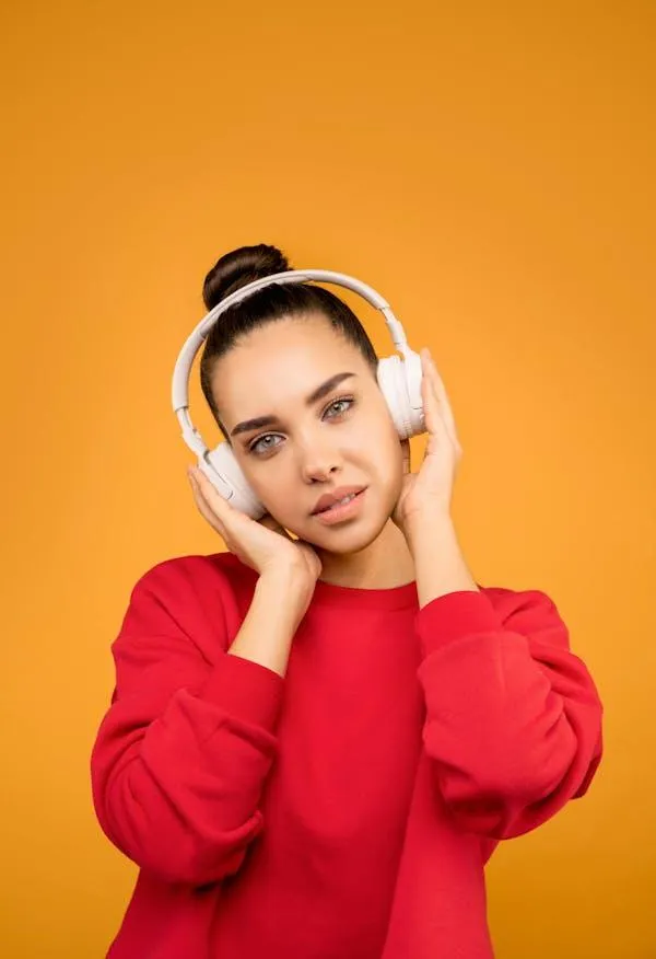 Young Woman in Red Hoodie Posing with an Orange Background