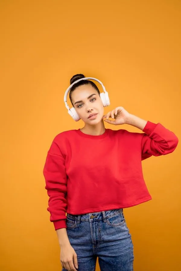 Young Woman in Red Sweater Posing on an Orange Background