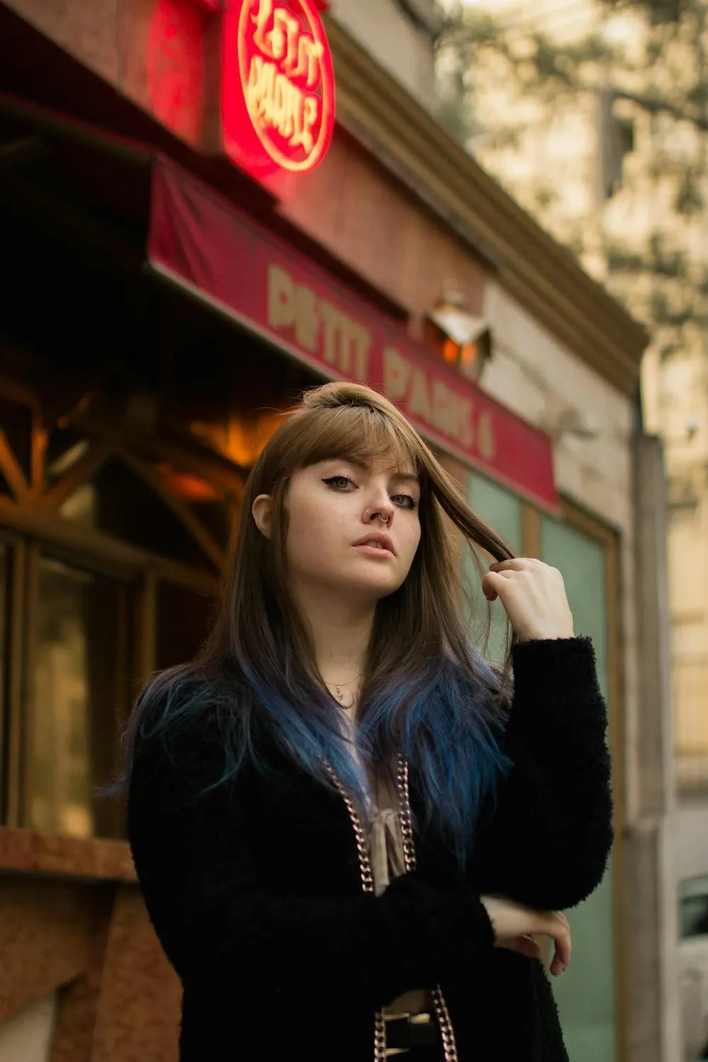 Young Woman Standing Outside a Cafe Looking Thoughtfully