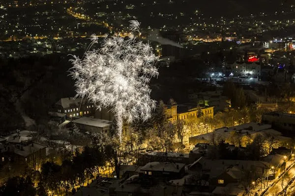 Aerial View of City Lights and Stunning Fireworks Display