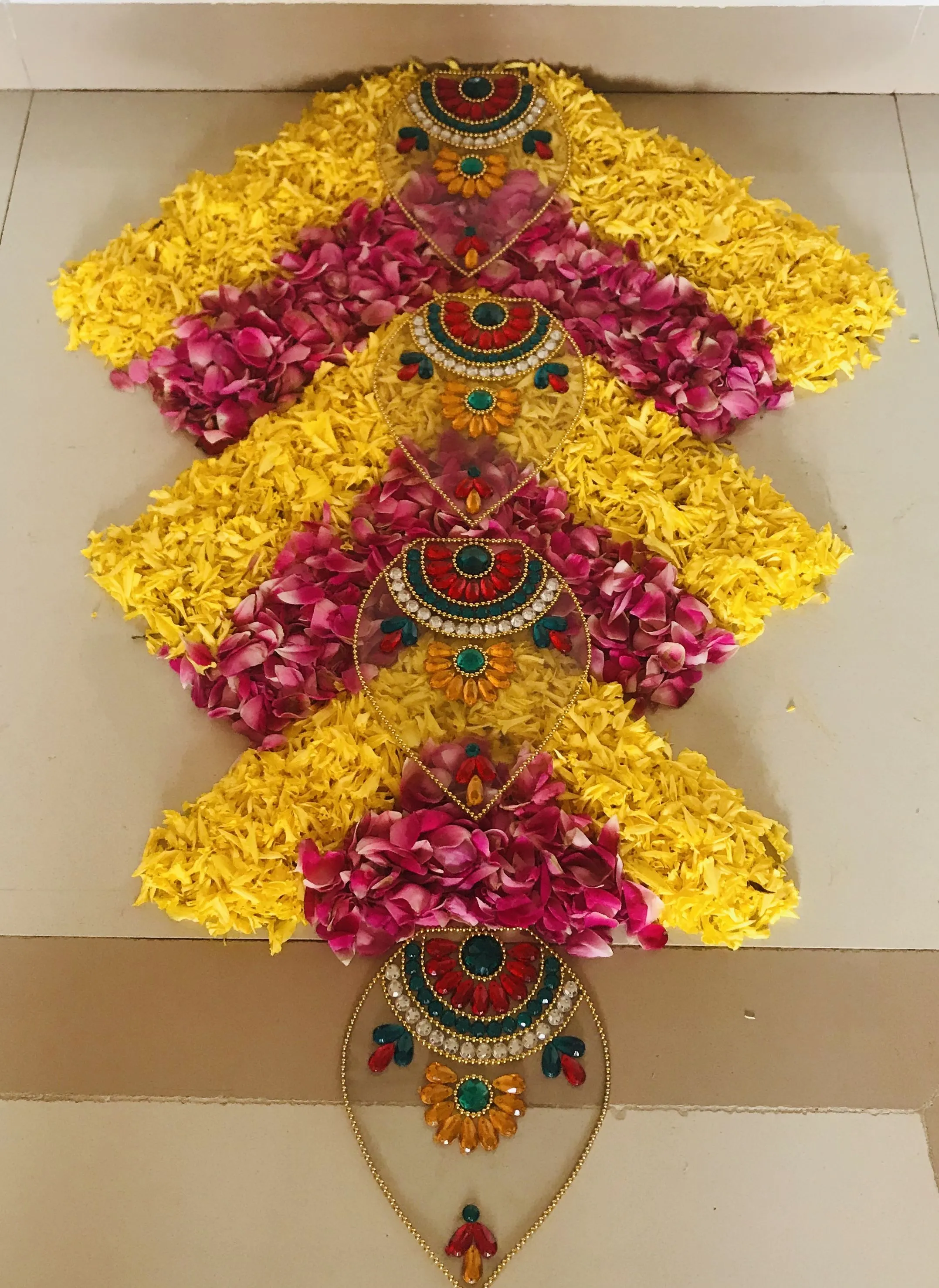 Arrow shape floral kolam with colourful bead decoration