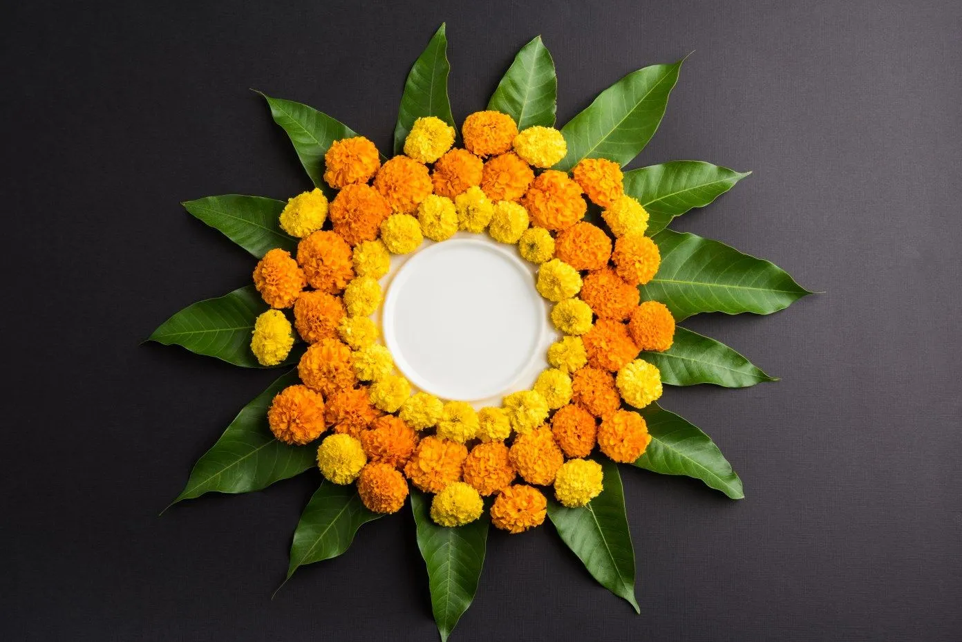 Athapookolam with orange and yellow flowers with leaves