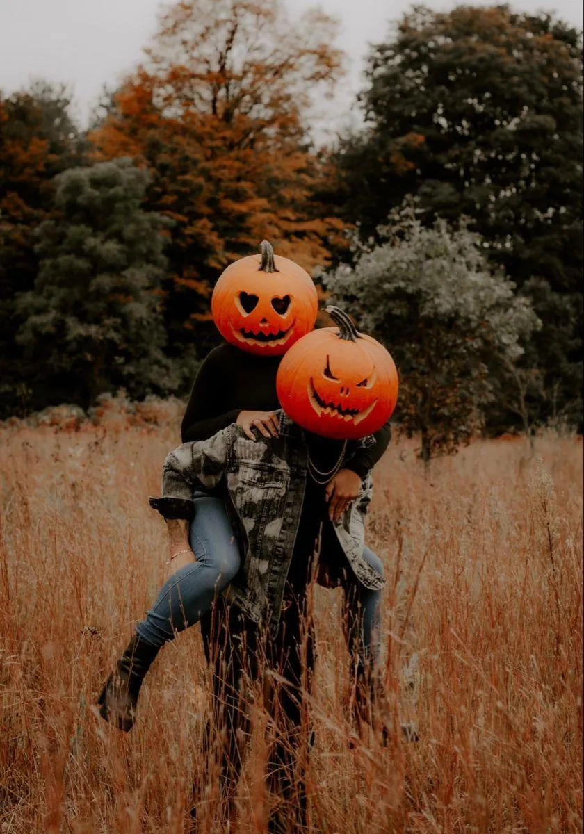 Autumn Field Fun with Couple in Pumpkin Heads Wallpaper