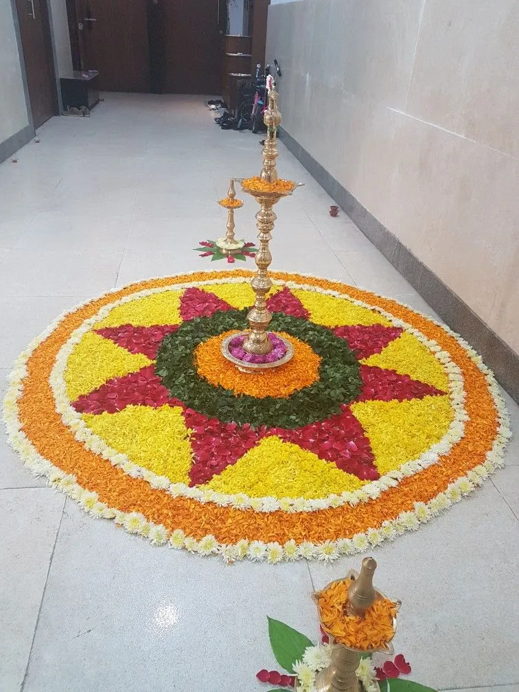 Beautiful concentric circle floral pookolam with lamp image