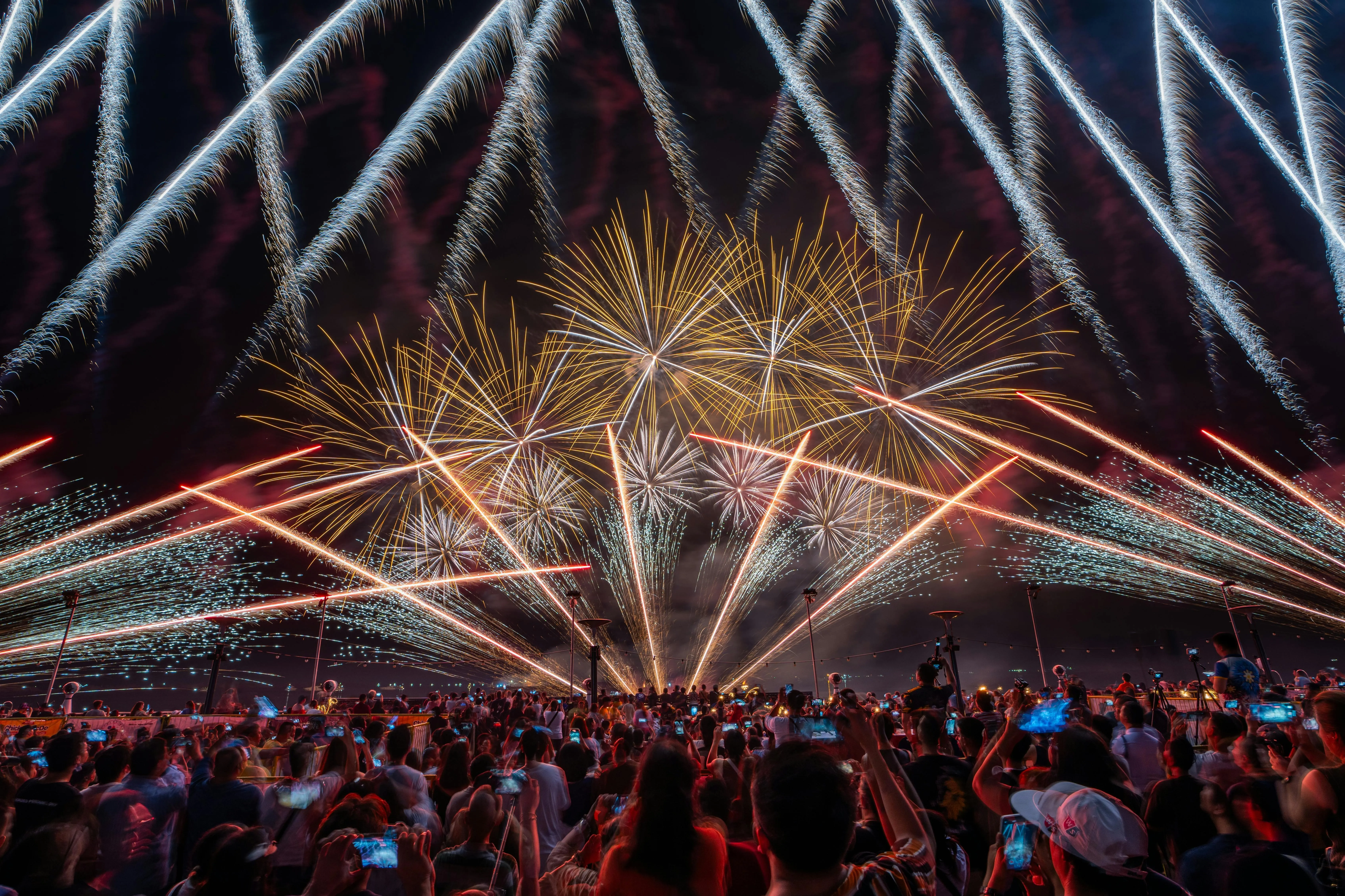 Beautiful Fireworks Display over the Night Sky and Crowd