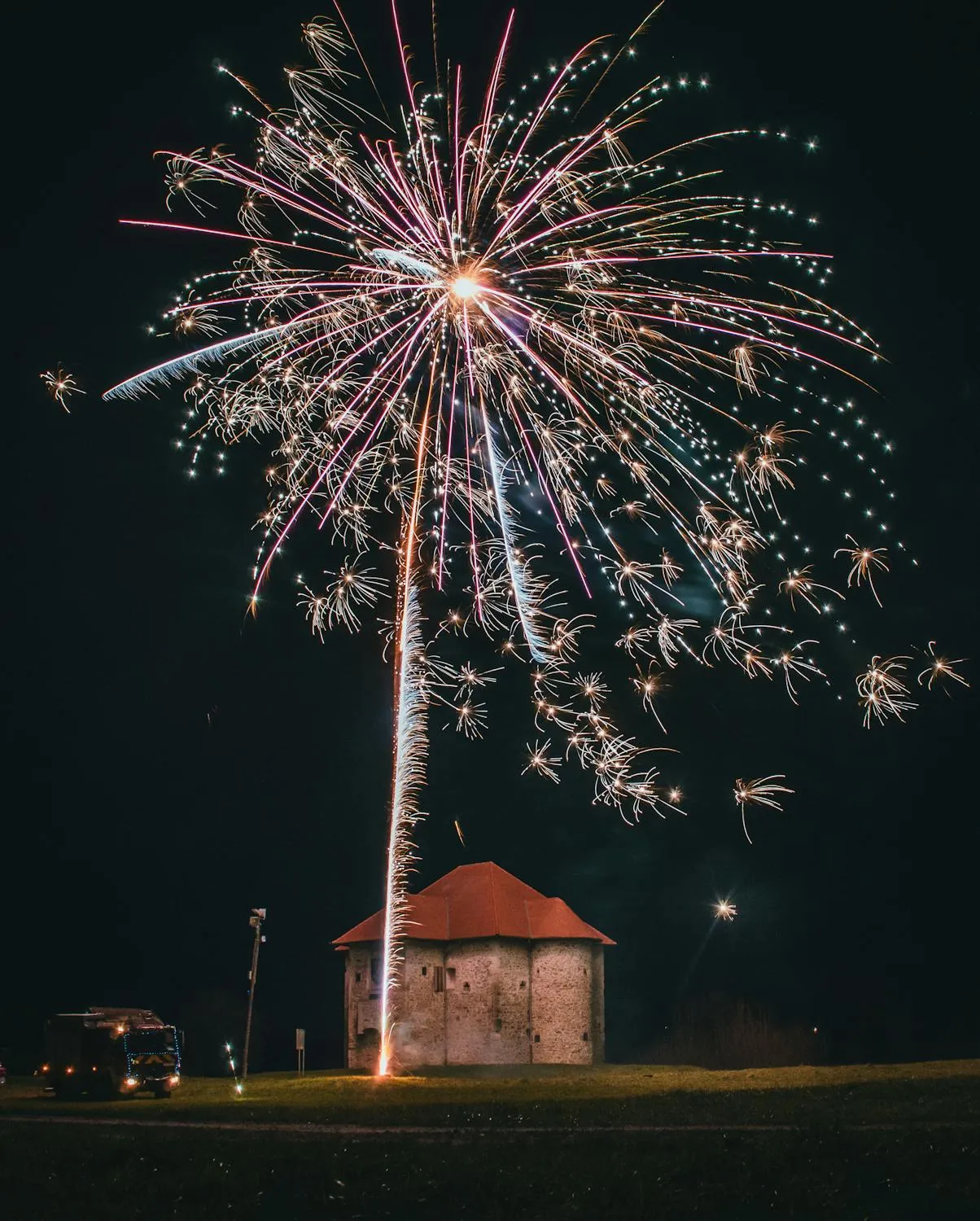 Beautiful fireworks exploding above a gazebo and night sky