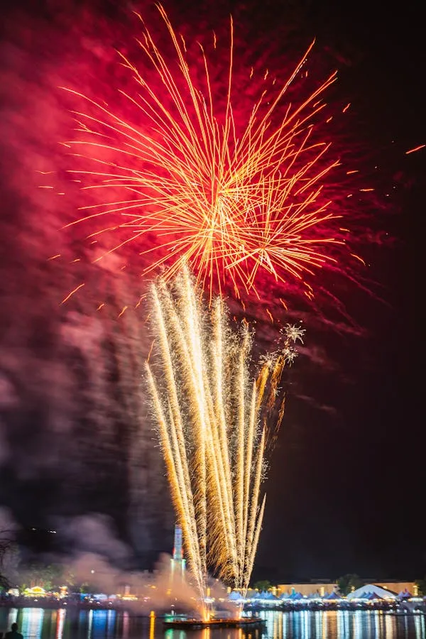 Beautiful fireworks exploding near a building at night