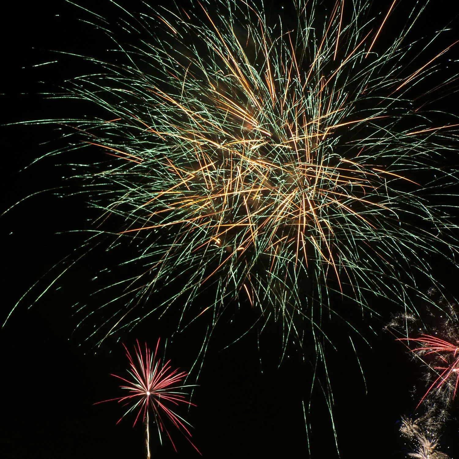 Beautiful Green and Red Fireworks Against Dark Sky Wallpaper