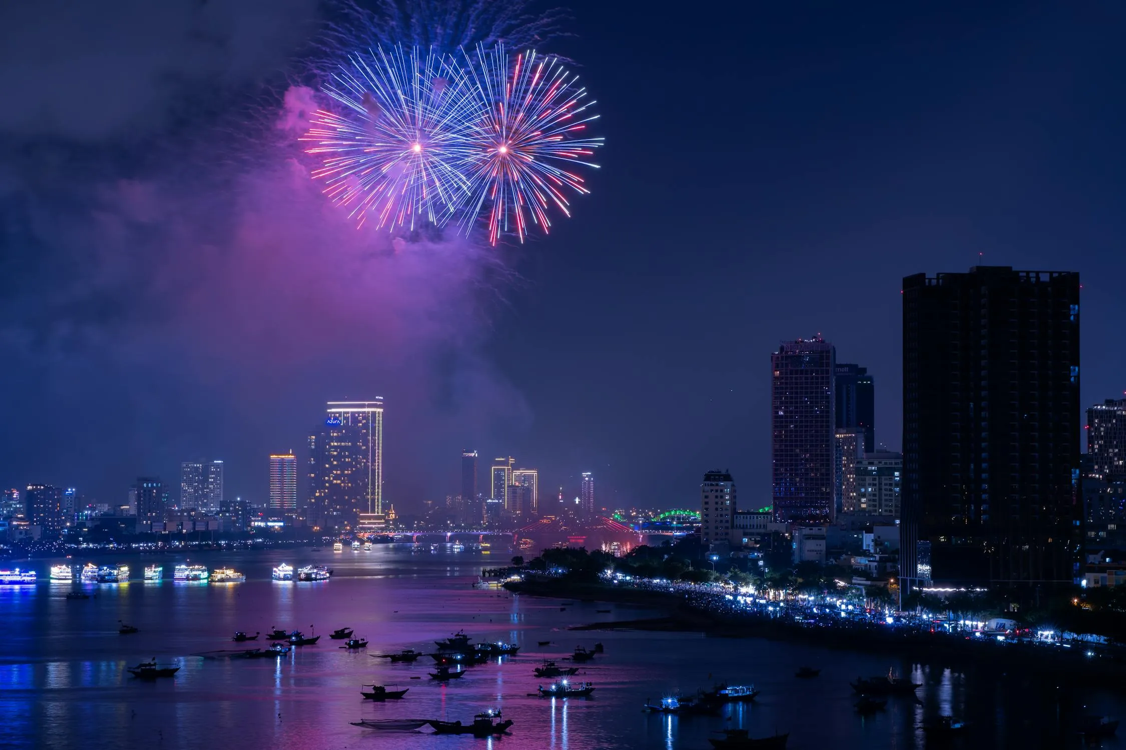 Bright and vivid fireworks bursting over a waterfront city