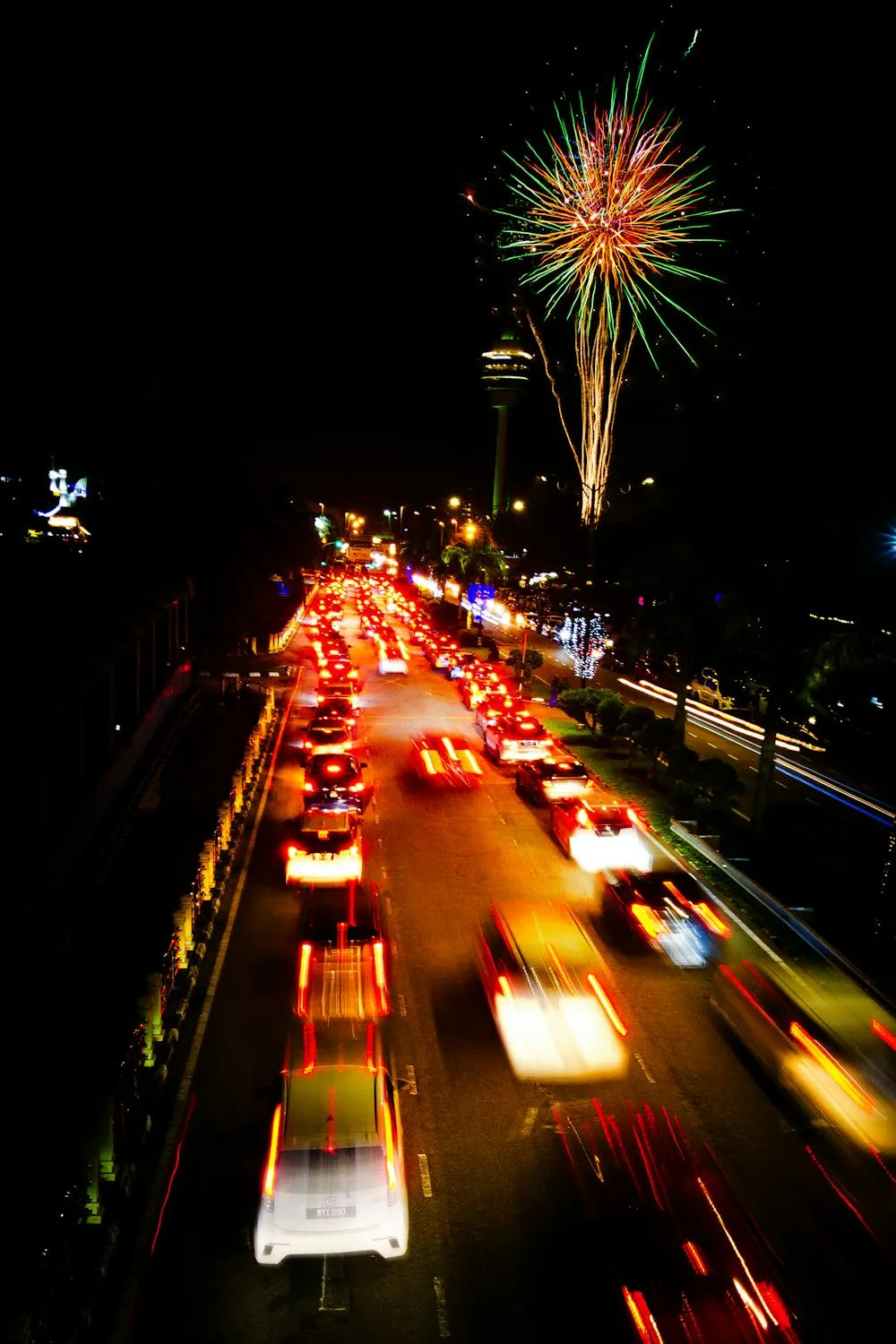 Bright city street lights with fireworks overhead wallpaper