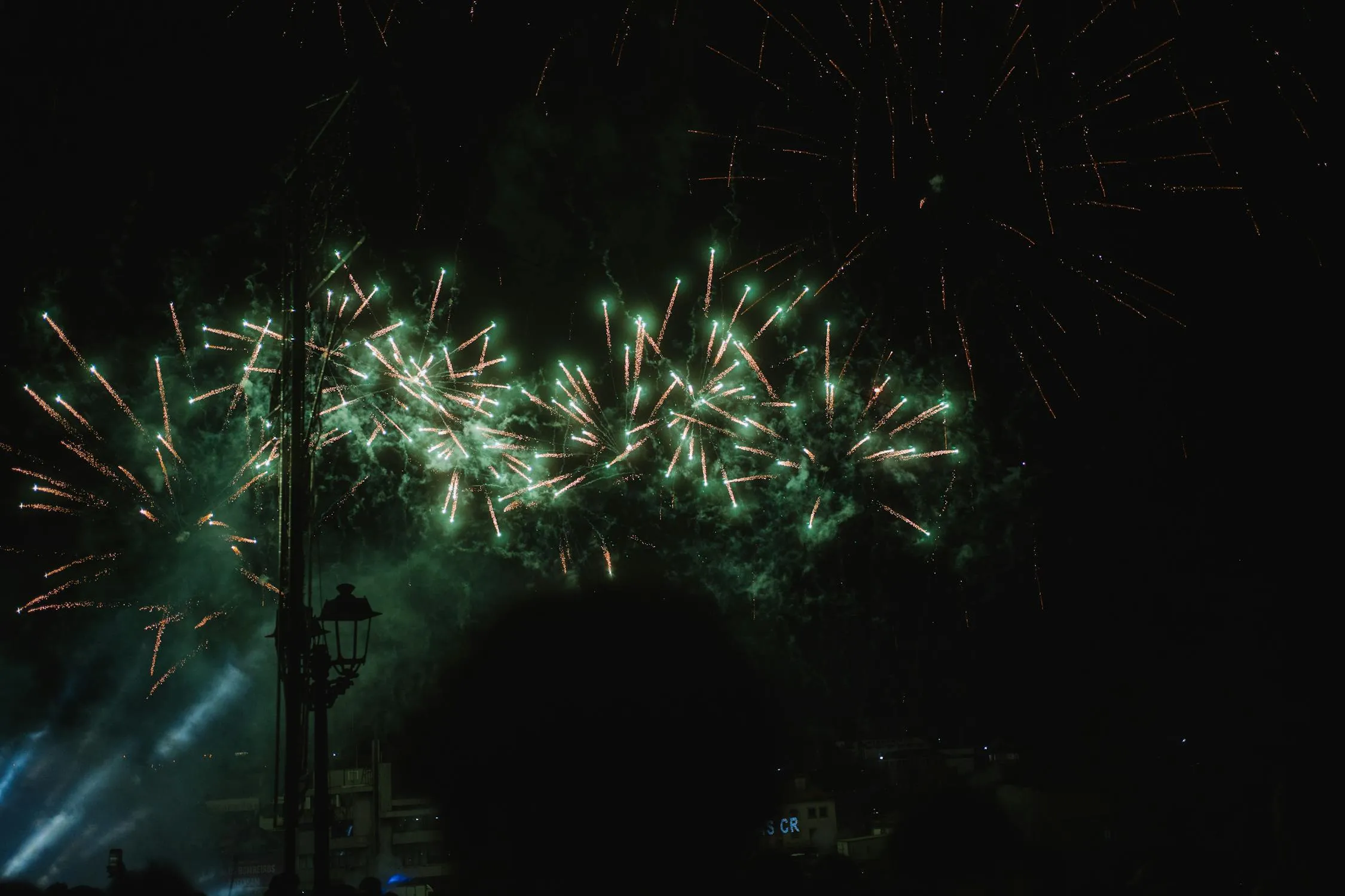 Bright fireworks in the dark sky over the city Wallpaper