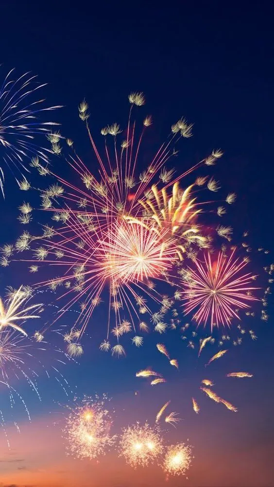 Bright fireworks reflecting against the dark sky Wallpaper