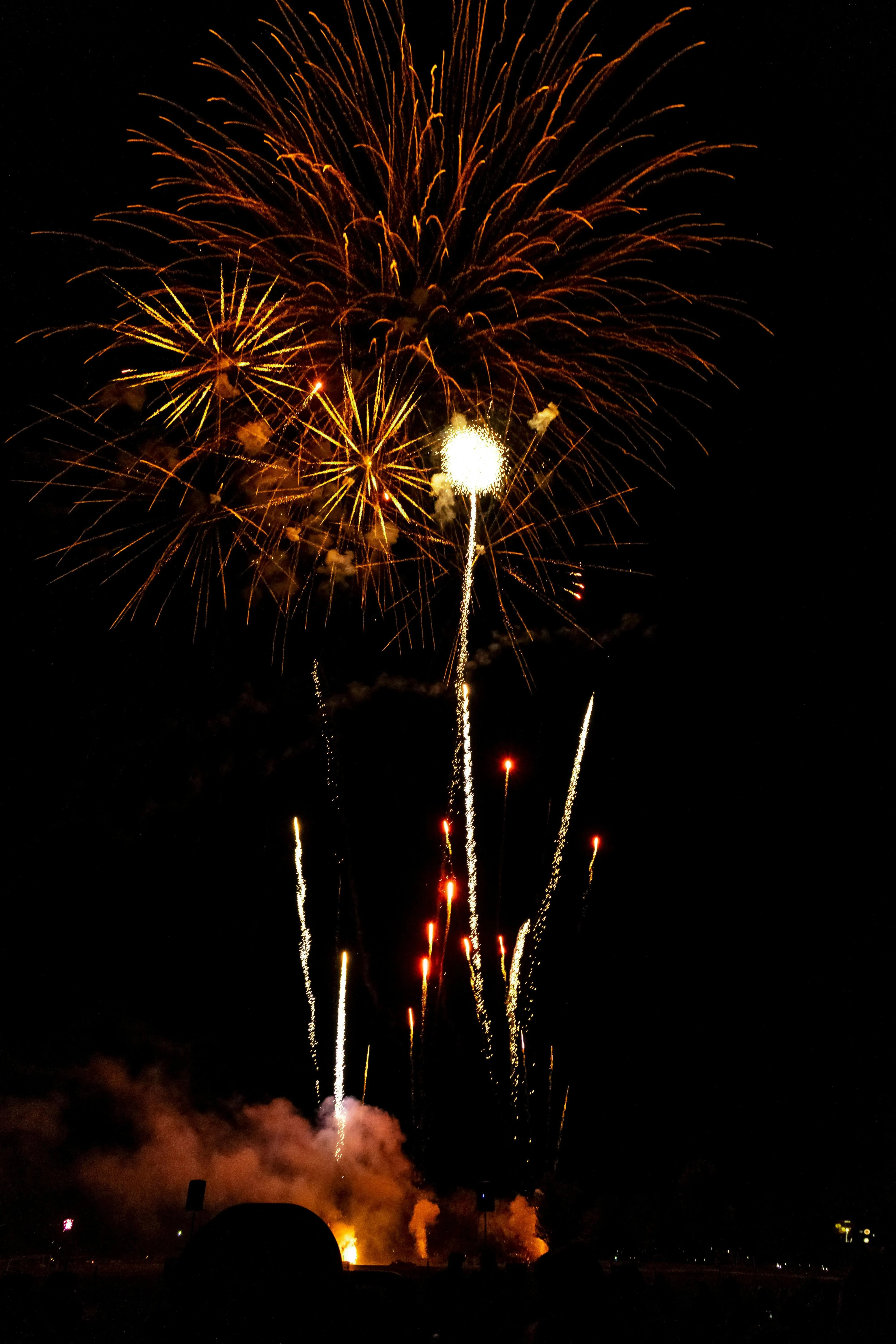 Bright golden Fireworks Display over Water at Night