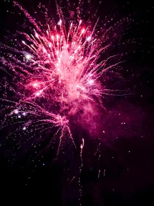 Bright purple and red fireworks exploding in the sky