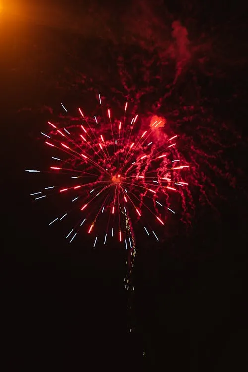 Bright Red Firework Bursting in the Night Sky Wallpaper