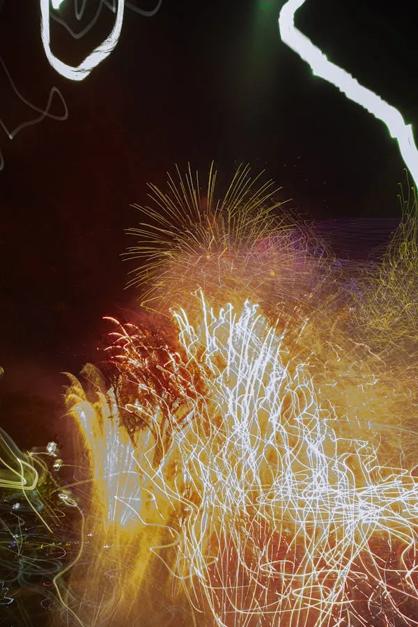 Bright white and orange fireworks bursting in the sky