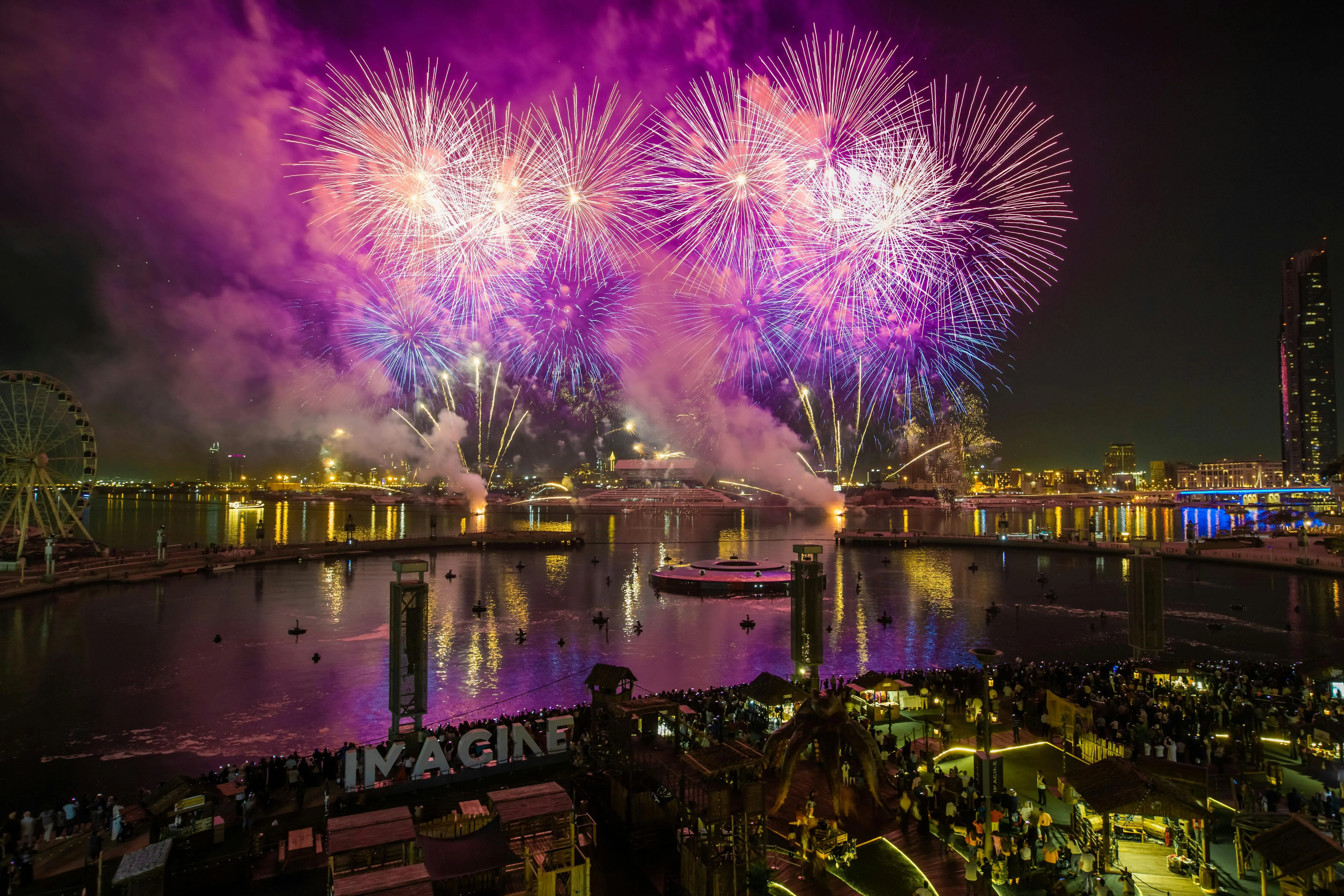 Brilliant fireworks illuminate the night sky near the water