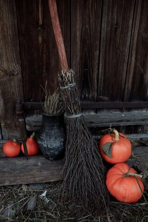 Broomstick and Pumpkins on Rustic Wooden Background Image