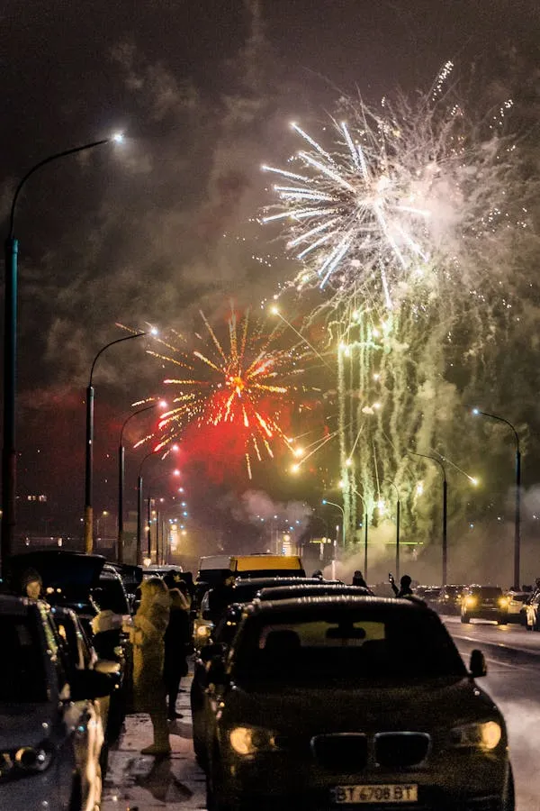 Cars and Fireworks Illuminating the Night City Streets