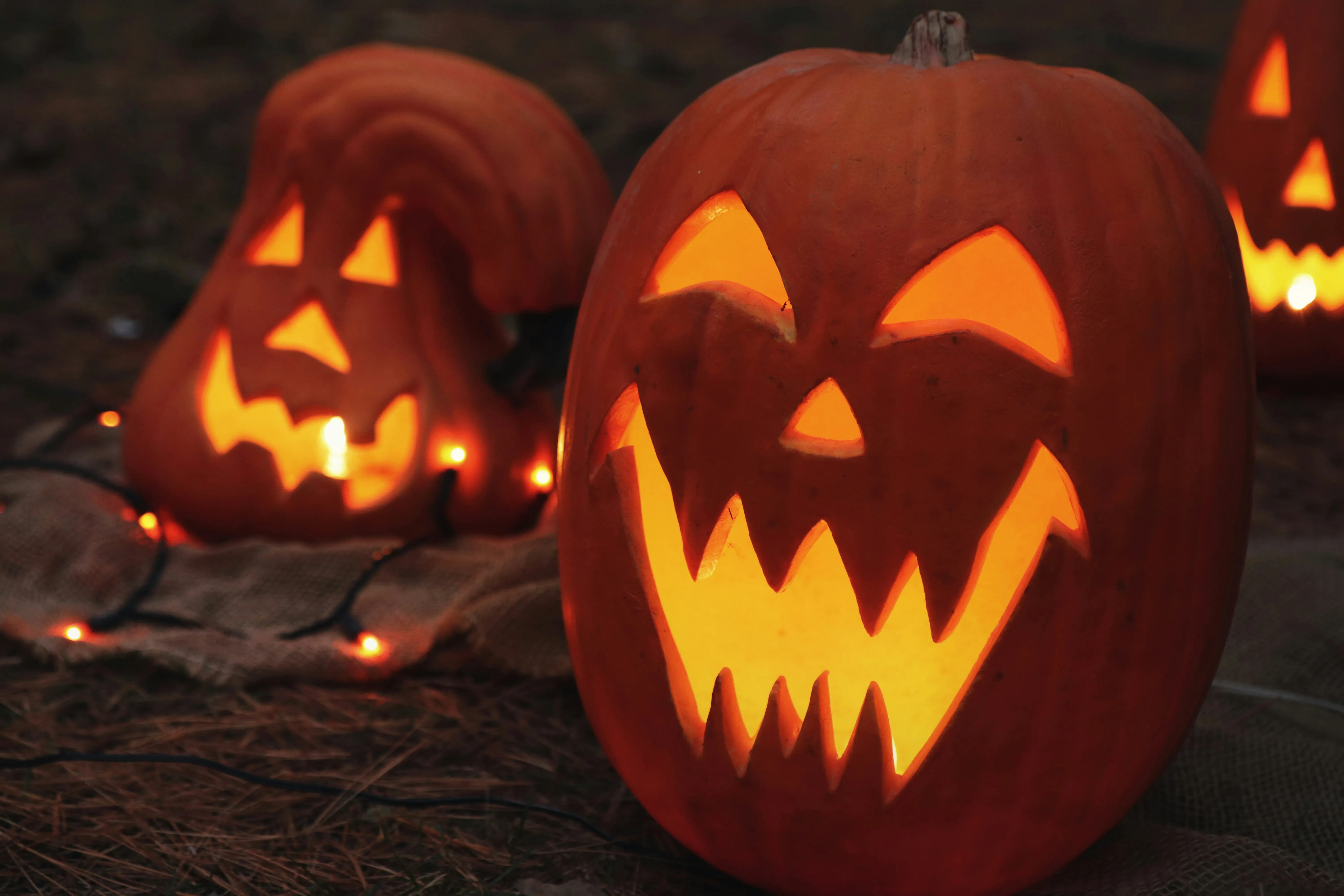 Carved Pumpkin with Sharp Teeth Glowing on Ground Wallpaper