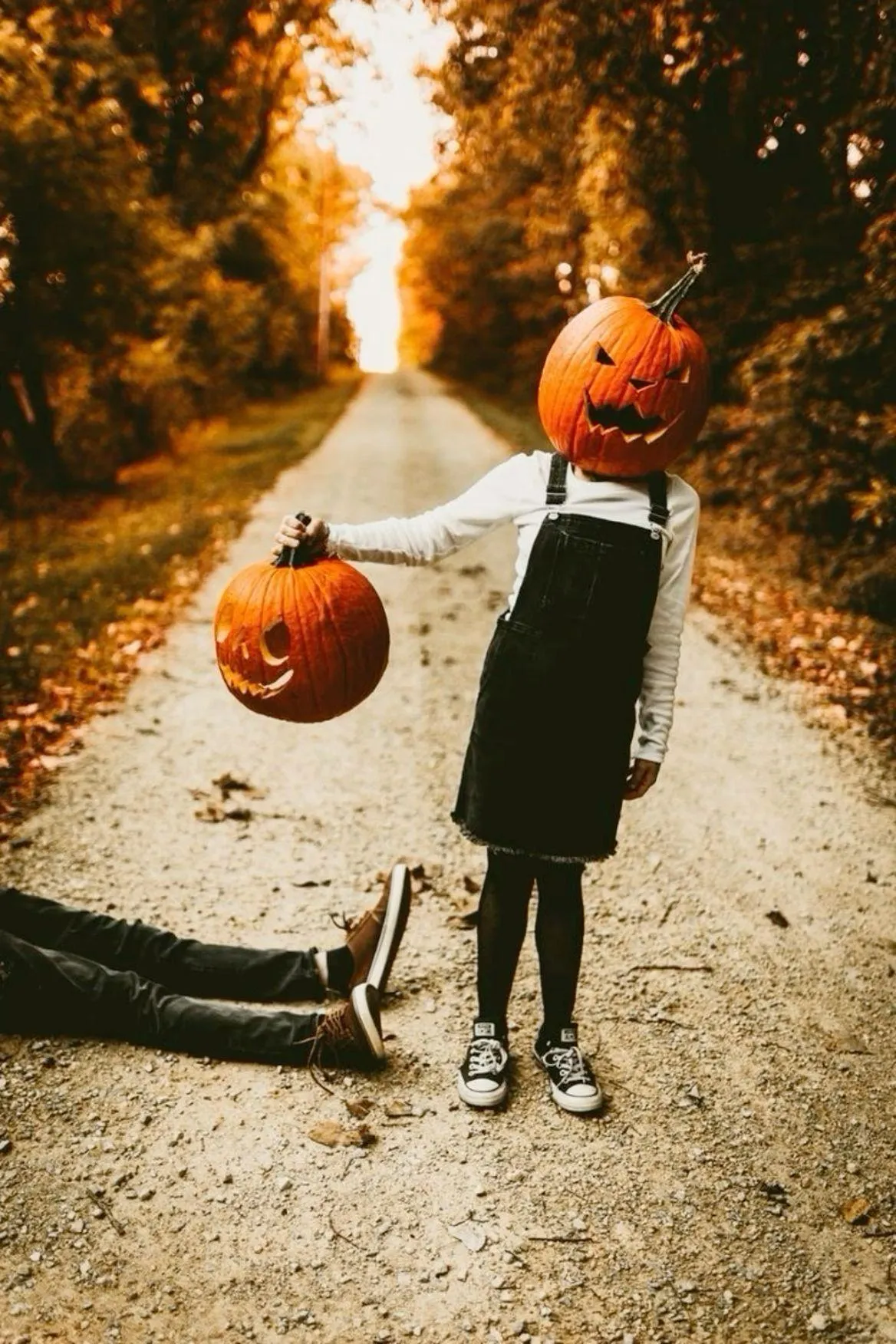 Child Tossing Pumpkin Balls on Autumn Pathway image