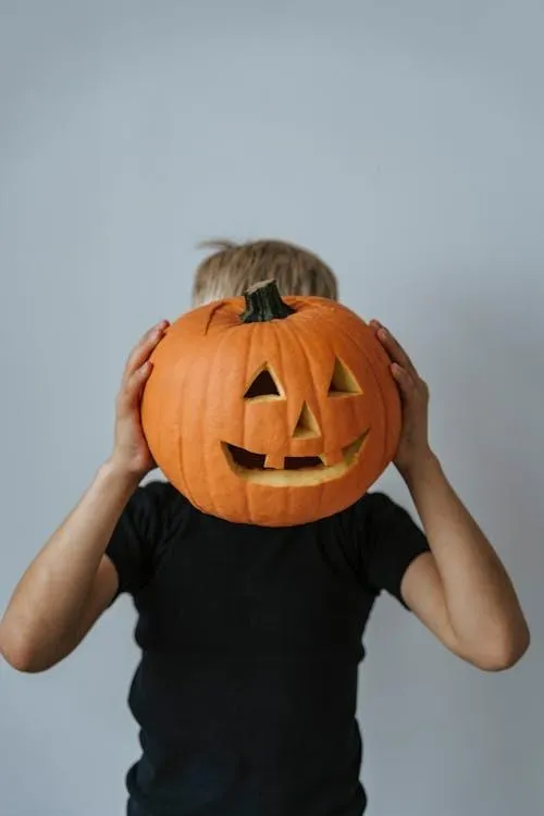 Child Wearing Carved Pumpkin as Halloween Costume HD