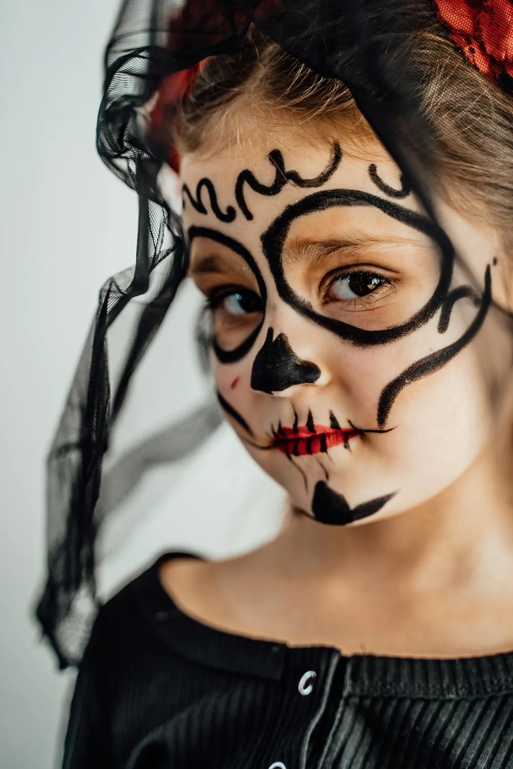 Child with Artistic Sugar Skull Face Paint for Halloween