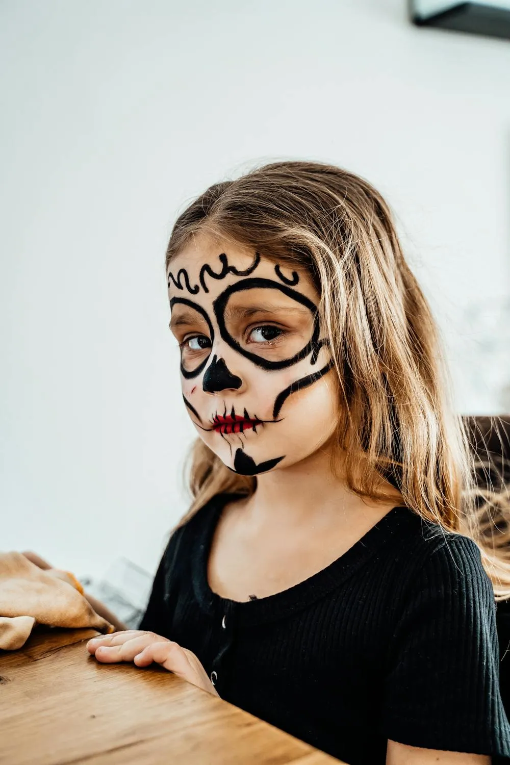Child with Detailed Sugar Skull Face Paint for Halloween
