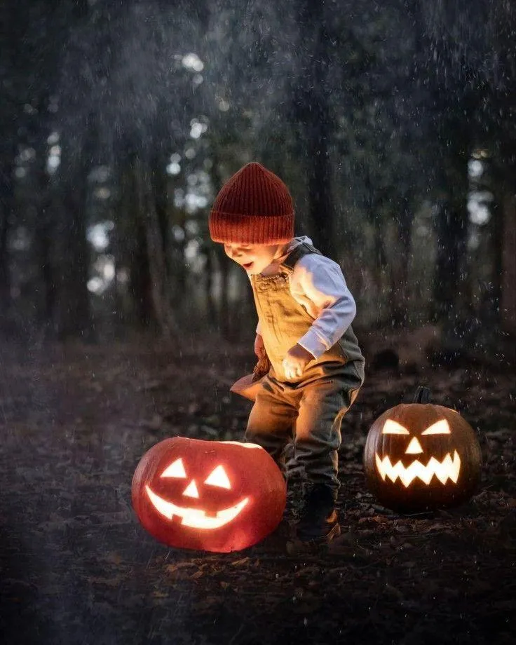 Child with Two Illuminated Jack o Lanterns Outside Wallpaper