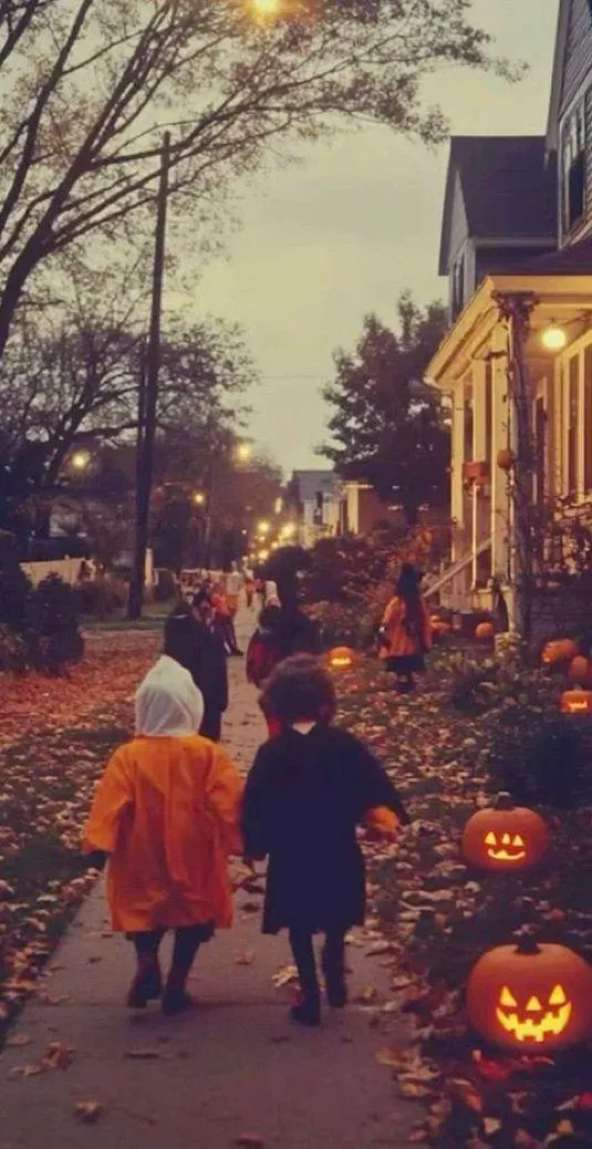 Children Walking Down in Pumpkin Lined Street During Halloween