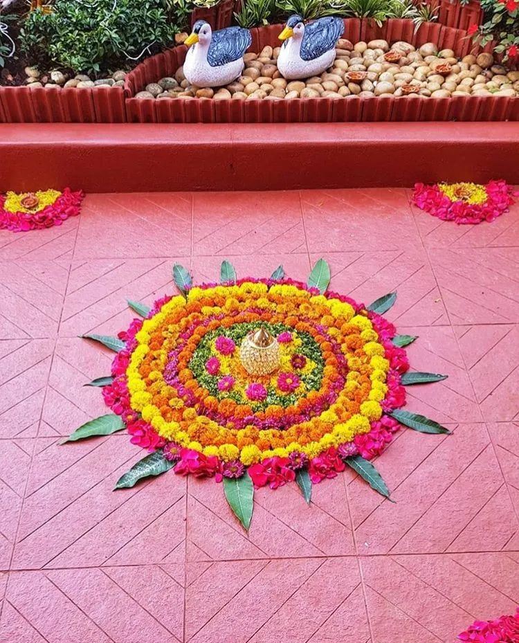 Circular Flower pookolam with Kalash in garden setting image