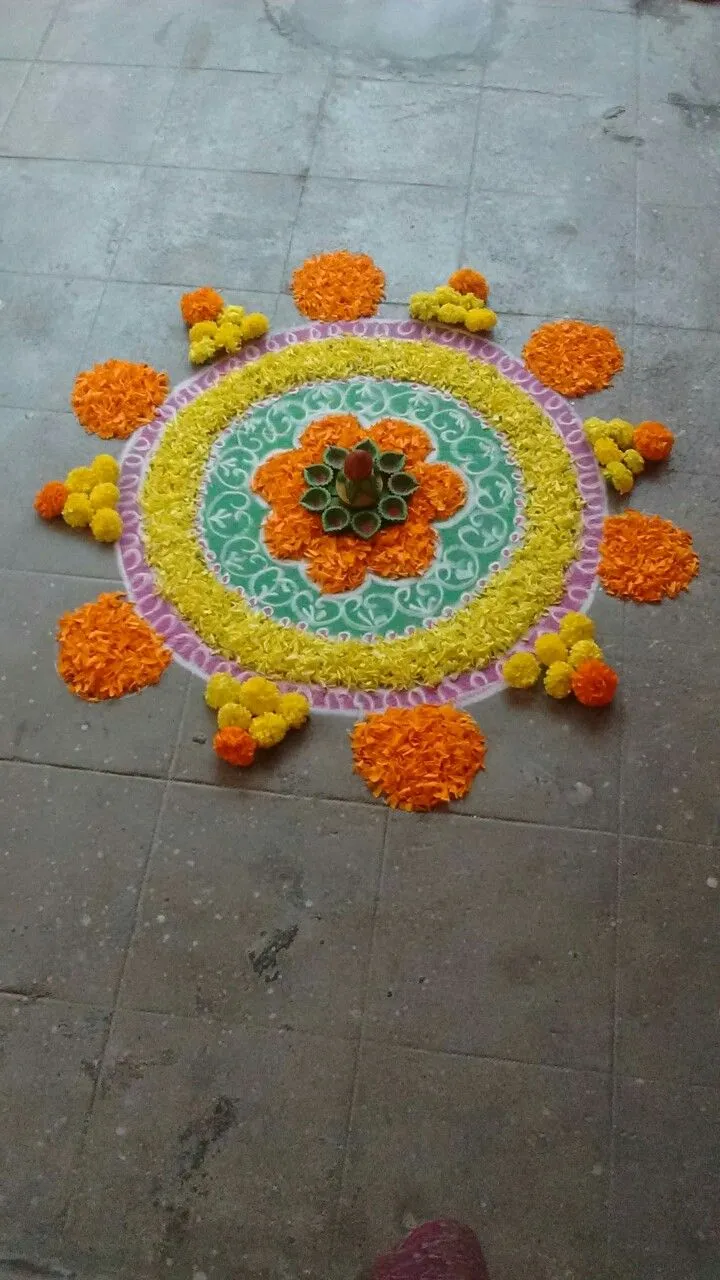 Circular kolam with rangoli art and marigolds HD image