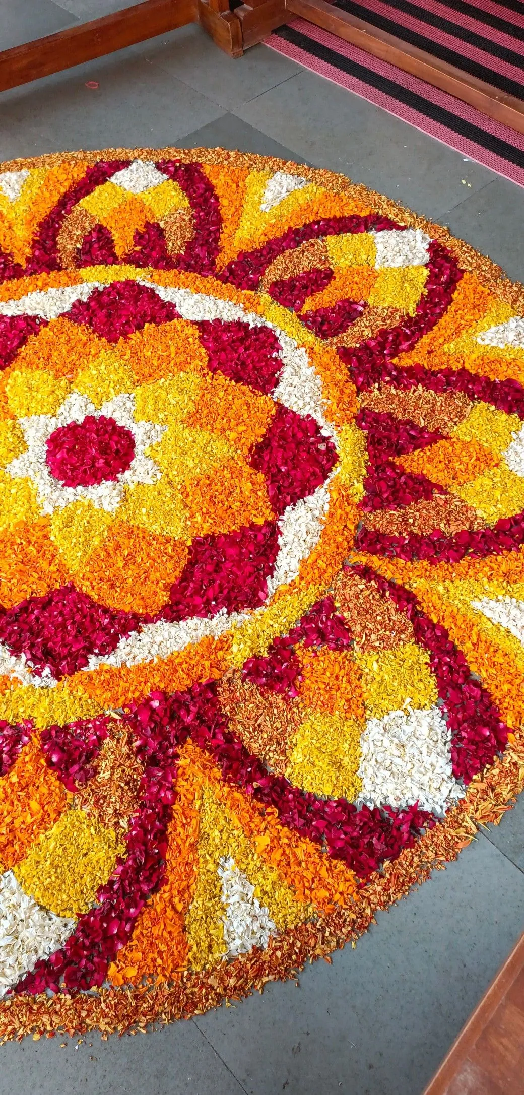 Circular Onam pookolam with orange and yellow petals image